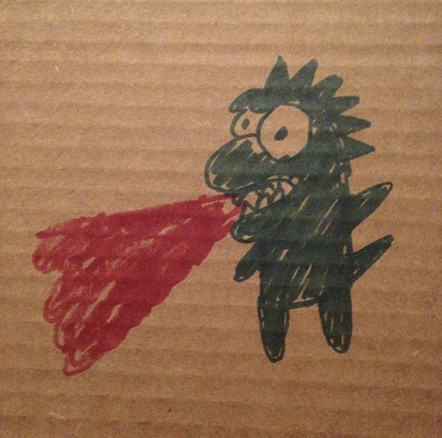 cardboard with a drawing of a fire breathing lizard in green